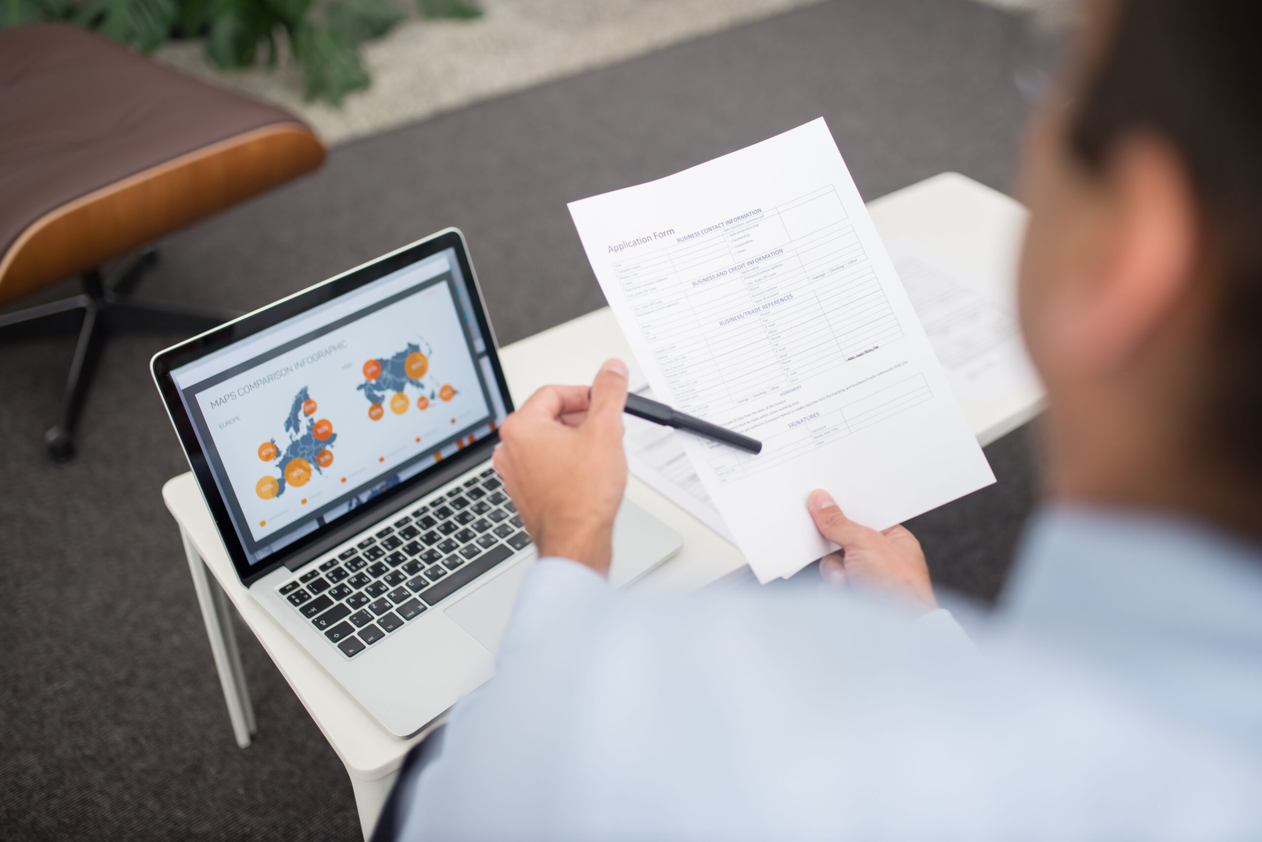 Professionnel consultant des documents numérisés sur ordinateur portable dans un bureau